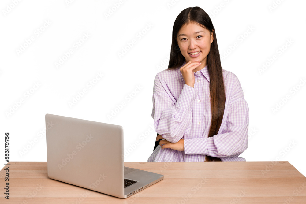 Young student asian woman in a workplace with a laptop isolated smiling happy and confident, touching chin with hand. Young student asian woman in a workplace with a laptop isolated smiling happy and confident, touching chin with hand.