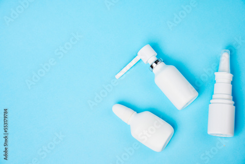 Nasal spray bottle on blue background with copy space