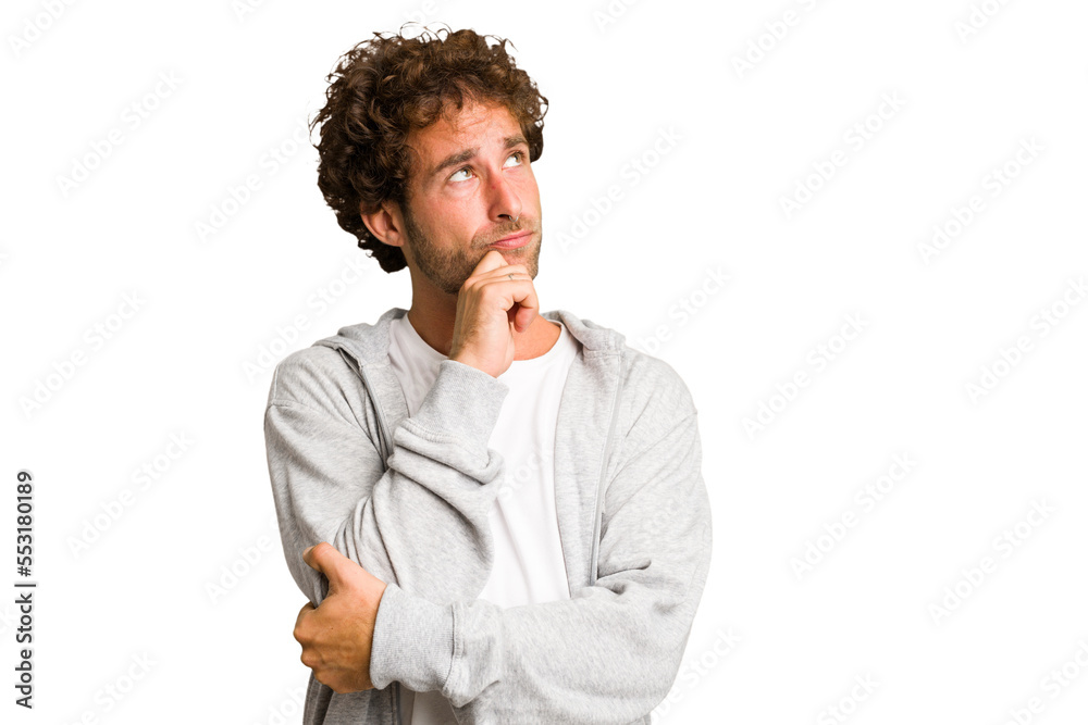Young curly smart caucasian man cut out isolated relaxed thinking about something looking at a copy space.