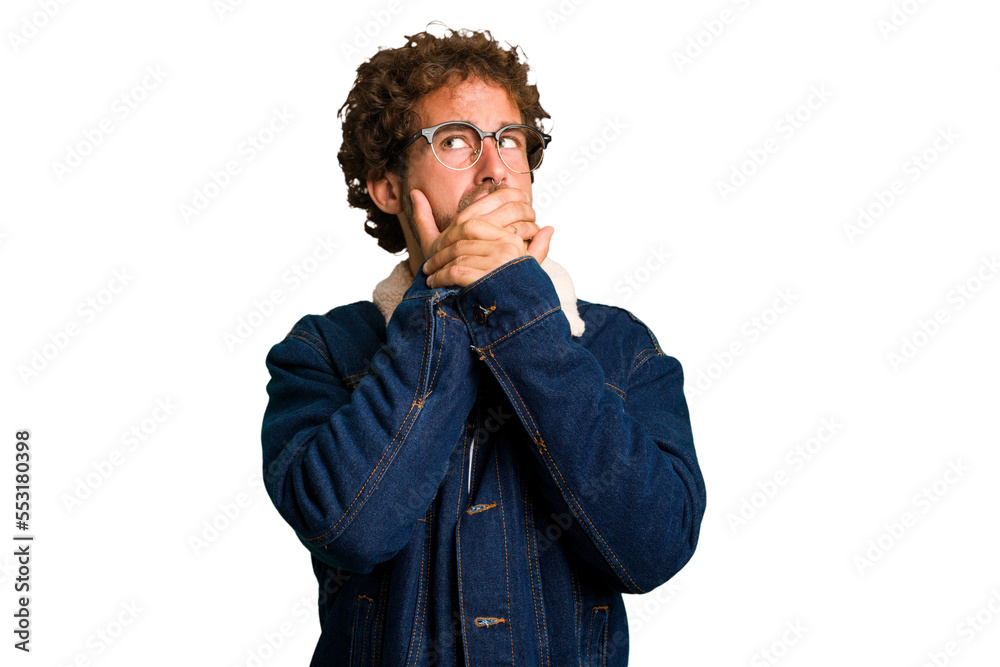 Young curly smart caucasian man cut out isolated thoughtful looking to a copy space covering mouth with hand. Young curly smart caucasian man cut out isolated thoughtful looking to a copy space covering mouth with hand.