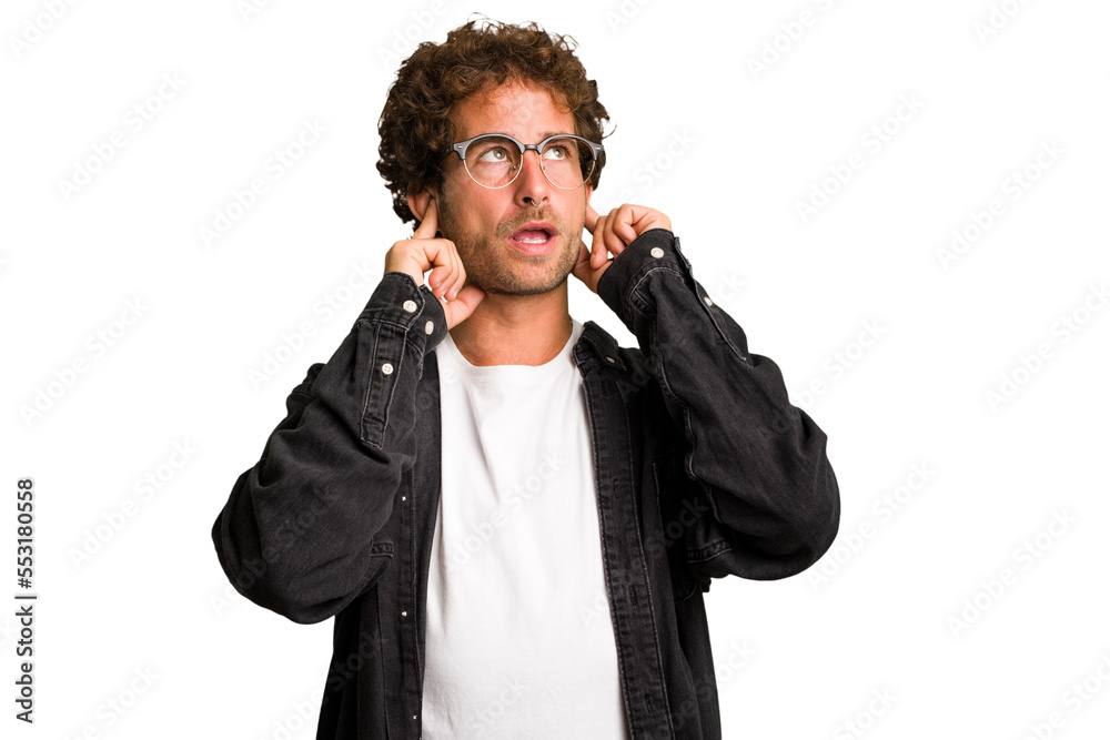 Young curly smart caucasian man cut out isolated covering ears with fingers, stressed and desperate by a loudly ambient. Young curly smart caucasian man cut out isolated covering ears with fingers, stressed and desperate by a loudly ambient.