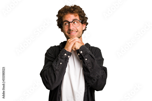 Young curly smart caucasian man cut out isolated praying for luck, amazed and opening mouth looking to front.