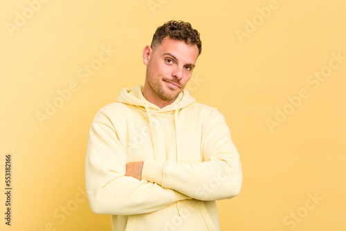 Young caucasian handsome man isolated on yellow background who is bored, fatigued and need a relax day. © Asier