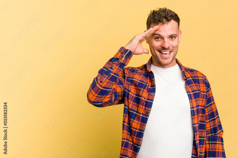 Young caucasian handsome man isolated on yellow background shouts loud, keeps eyes opened and hands tense. Young caucasian handsome man isolated on yellow background shouts loud, keeps eyes opened and hands tense.