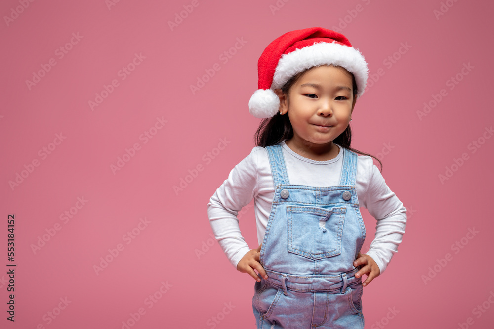 Cute little girl in santa hat looking happy and sweet Cute little girl in santa hat looking happy and sweet