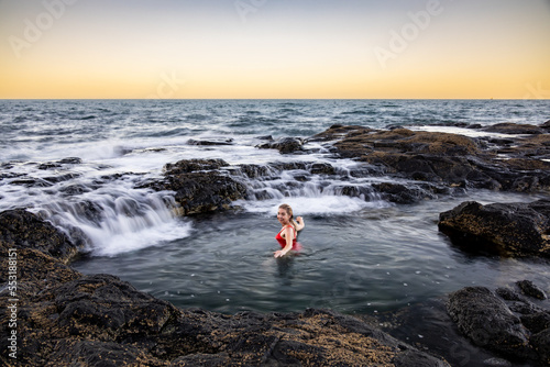 Blonde woman bathing in ocean rock pool photo