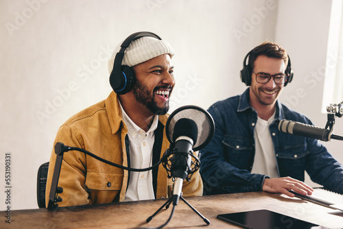 Happy radio presenter speaking into a microphone in a studio photo