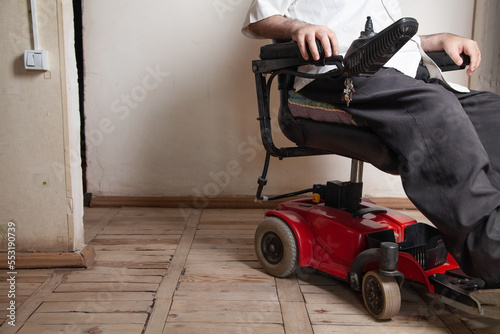 Disabled man using joystick in electric wheelchair.