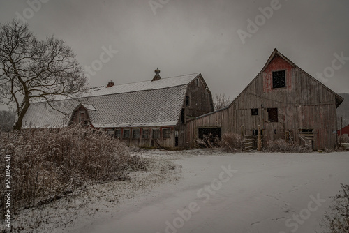 Abandoned barn during a snow shower