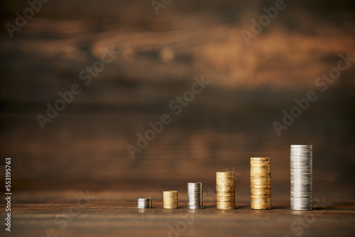 Coins stack growing business with copy space for text on wooden background