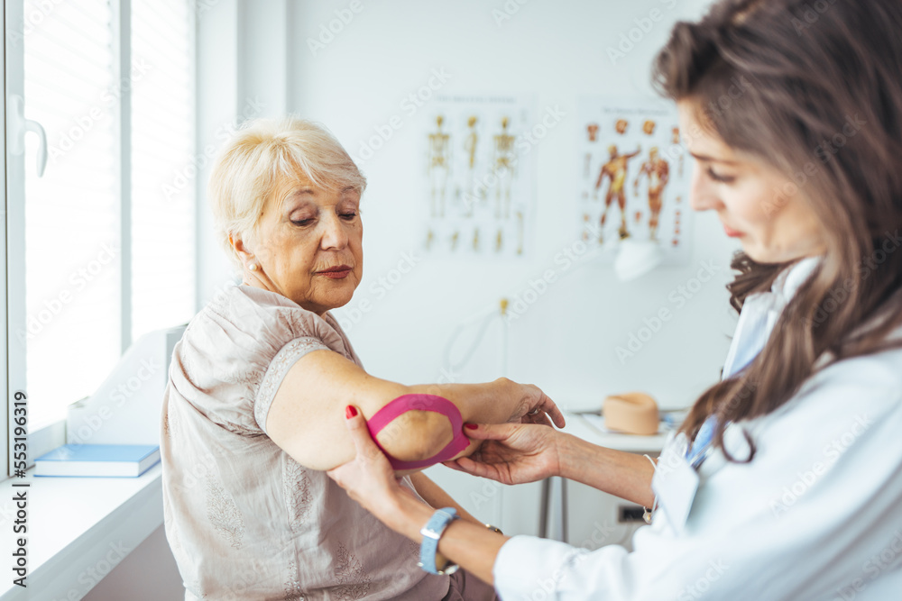 Fototapeta premium Female doctor chiropractor or osteopath fixing womans shoulder with hands movements during visit in manual therapy clinic. Support for strained muscles. Physical therapy diagnosing concept