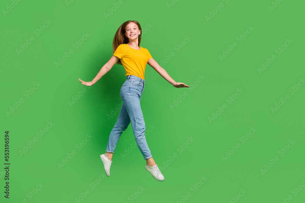 Full body portrait of overjoyed adorable person jumping have good mood isolated on green color background Full body portrait of overjoyed adorable person jumping have good mood isolated on green color background