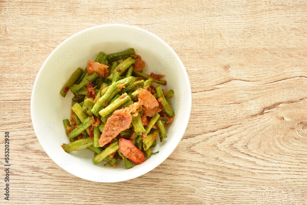 spicy stir fried slice yard long bean with fat pork in curry sauce on bowl spicy stir fried slice yard long bean with fat pork in curry sauce on bowl