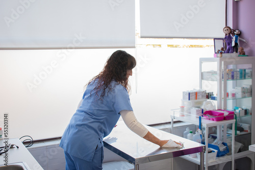 Female veterinarian cleaning the examination table.