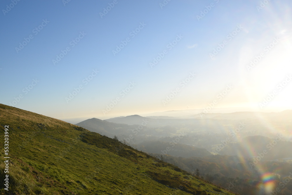 Naklejka premium the top of the Malvern hills on a misty day during sunset