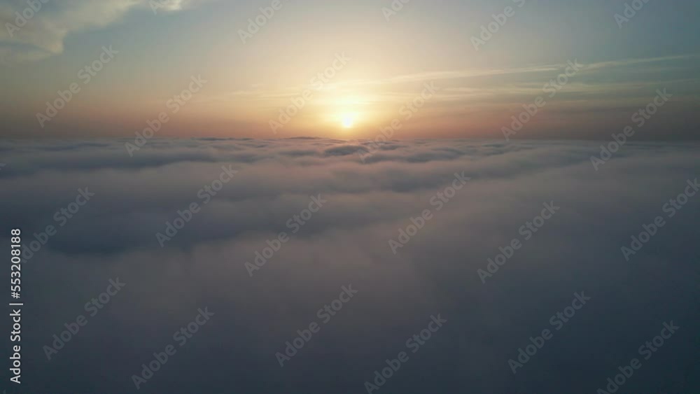 View from the cockpit of an airplane above the clouds at sunrise.