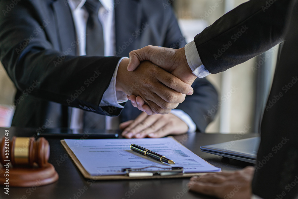 Lawyer shaking hands with client after agreement Gavel Justice hammer on wooden table with judge and client shaking hands after advice in courtroom, notary service concept Lawyer shaking hands with client after agreement Gavel Justice hammer on wooden table with judge and client shaking hands after advice in courtroom, notary service concept