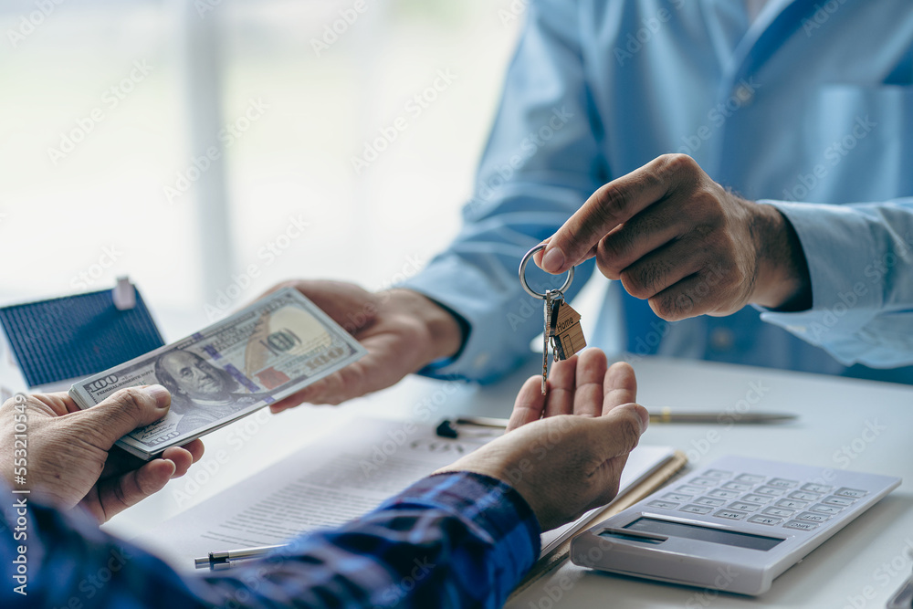 Fototapeta premium Real estate agent holding house keys for his client after contract signing Move house or rent Home buying ideas and home insurance for real estate