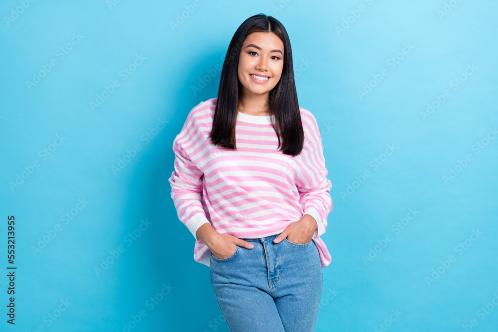 Photo of cheerful pretty young girl dressed pink pullover smiling walking arms pockets isolated blue color background Photo of cheerful pretty young girl dressed pink pullover smiling walking arms pockets isolated blue color background