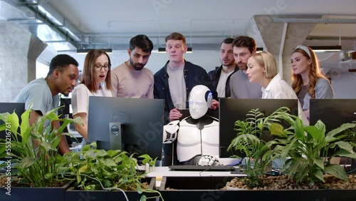 Portrait smart futuristic cyborg with artificial intelligence working in IT company using computer doing tasks. Group of people worker of office watching white robot solving problems online applauding