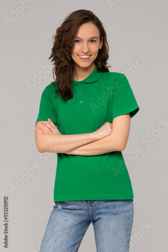 Green polo on a young woman in jeans, isolated, with copy space, mockup.