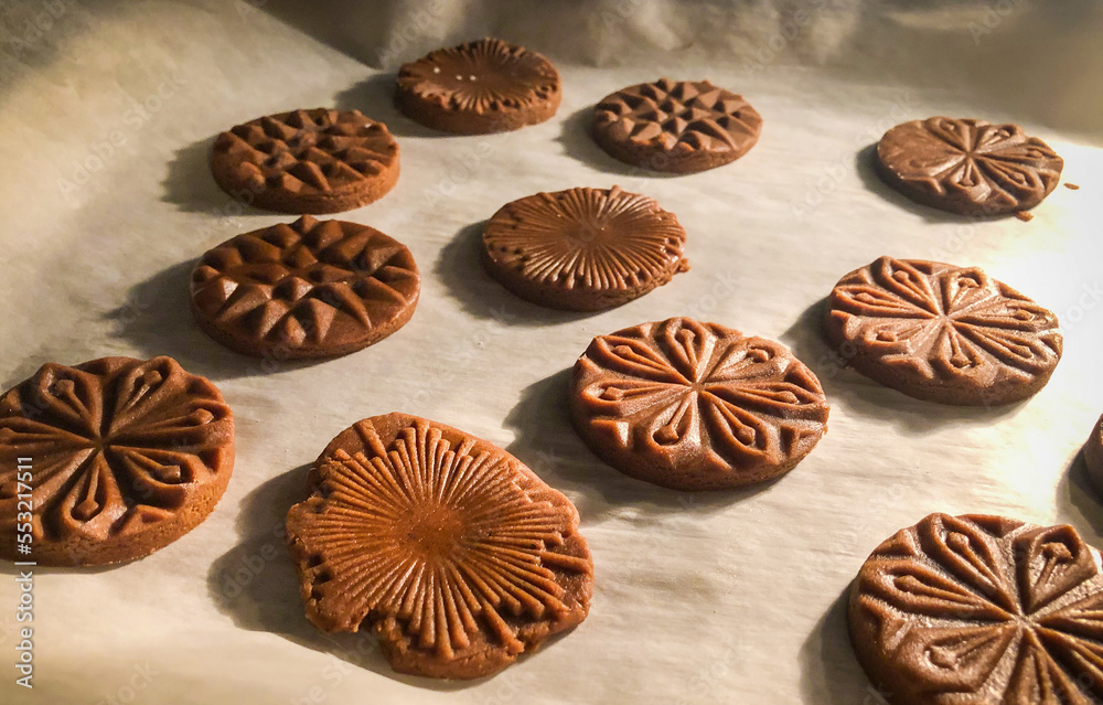 close up of pressed gingerbread cookies baking in the oven on parchment paper close up of pressed gingerbread cookies baking in the oven on parchment paper