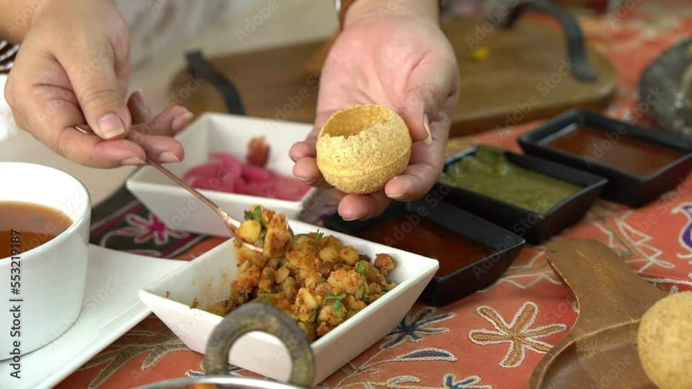 Close-up of Indian woman's hand showing how to eat Pani puri, which is to food culture of Indians, to Indian people and food concept.