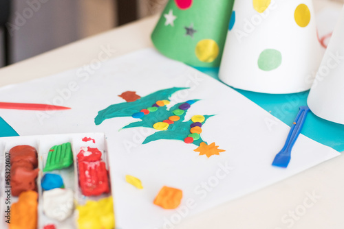 Making handmade Christmas cards. Childrens DIY concept. Little girl doing Christmas tree decoration or greeting cards from plasticine. Crafts for children.