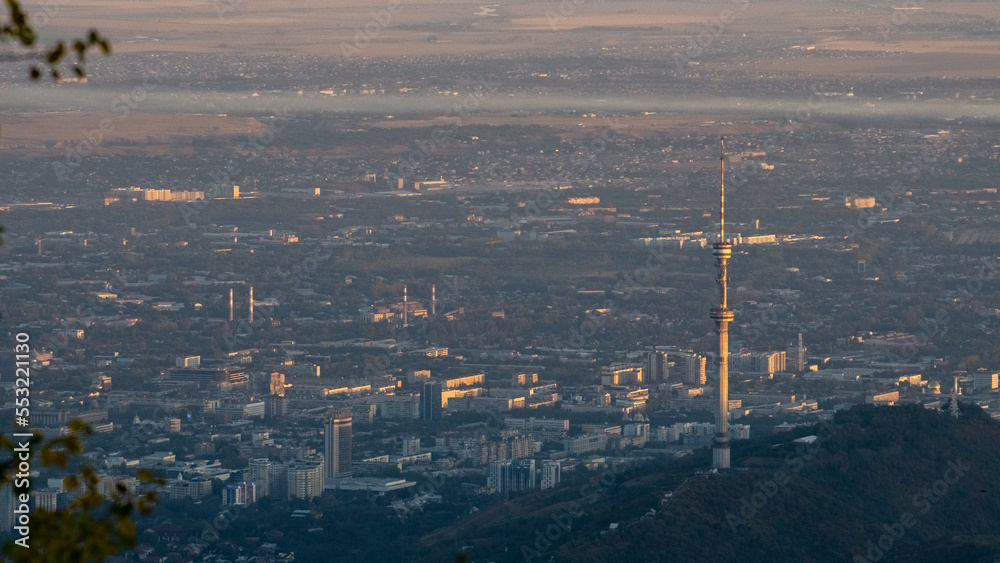 Obraz premium TV tower on the background of the city. a city at the foot of the mountains