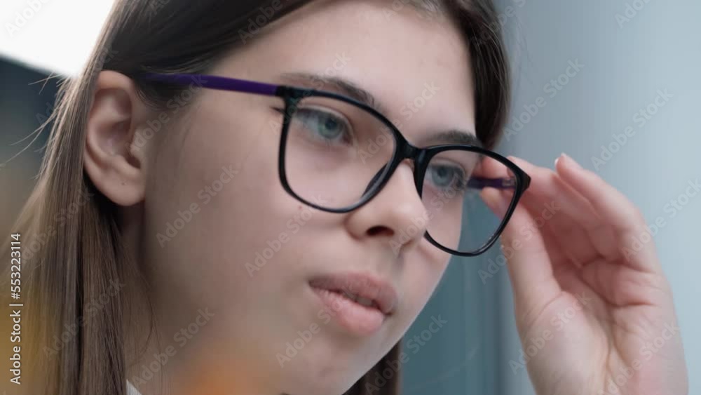 Close-up Portrait of Girl with Eye Glasses Working at Laptop. Young Woman Looking Into Laptop Screen. Girl Studying Online Close-up Portrait of Girl with Eye Glasses Working at Laptop. Young Woman Looking Into Laptop Screen. Girl Studying Online