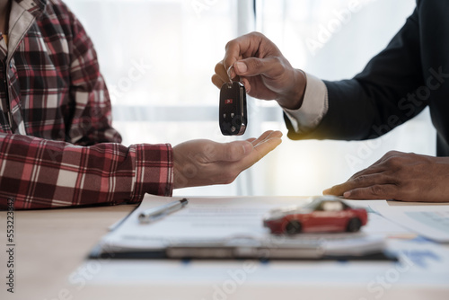 Loan approver, businessman in suit, man giving car keys after car loan approval and contract signing