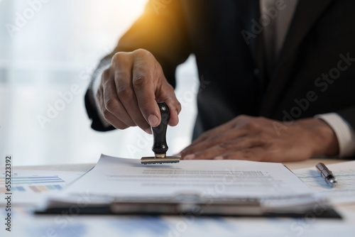 Fotografie Loan approver, businessman in suit, man using stamp for car loan approved