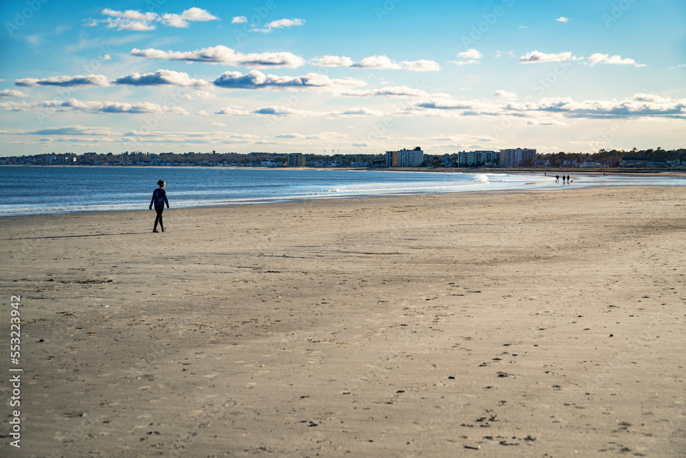 A woman walking on a beach in Maine in the wintertime