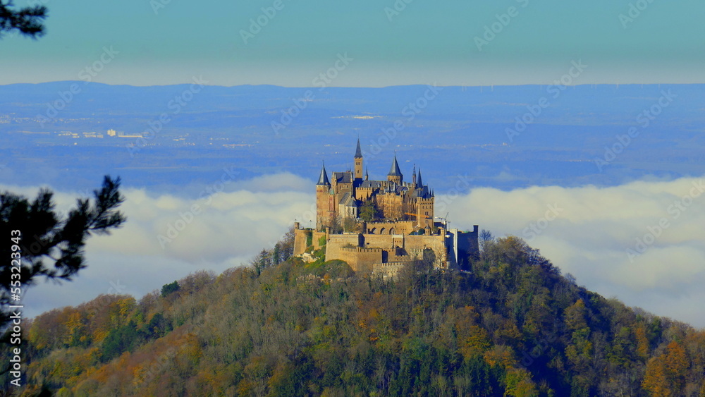 Burg Hohenzollern steht auf Berggipfel im Wald über den Wolken an sonnigem Herbsttag