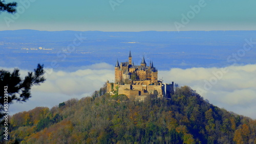 Burg Hohenzollern steht auf Berggipfel im Wald über den Wolken an sonnigem Herbsttag