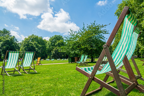 Sunshine and garden deck chairs in a park in London photo