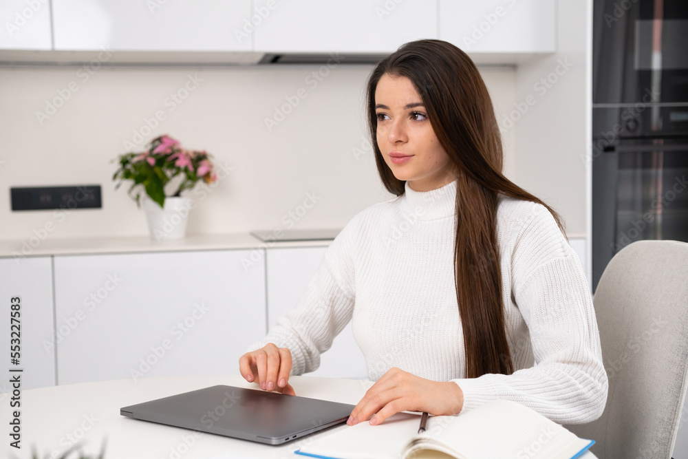 Smart pretty young woman closes a laptop after a lecture online at home. Smart pretty young woman closes a laptop after a lecture online at home.