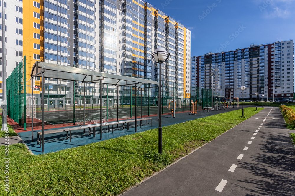 Obraz premium Courtyard of a residential area of St. Petersburg, Russia with a sports ground and a path for cyclists, on a sunny day against the backdrop of apartment buildings