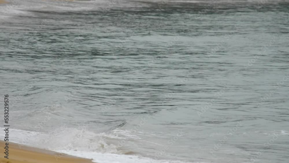 Blue sea with a yellow sandy beach close-up, azure clear water, wet sandy shore Blue sea with a yellow sandy beach close-up, azure clear water, wet sandy shore