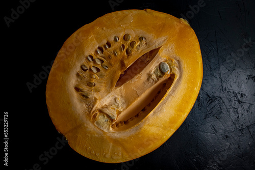 Half of a pumpkin on a black background, top view of a cut pumpkin