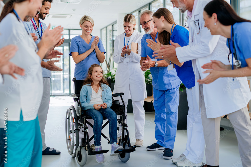 Medical staff clapping to little girl patient who recovered from serious illness. Medical staff clapping to little girl patient who recovered from serious illness.