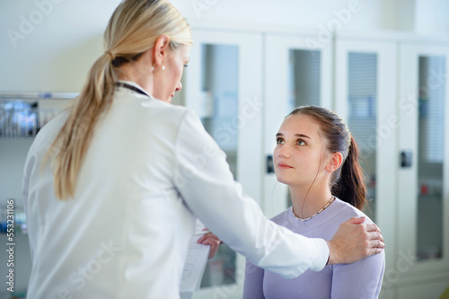Close-up of doctor consoling unhappy teenage girl in her ambulance office.