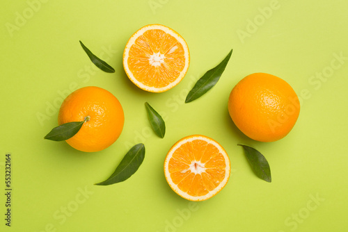 Fototapeta Naklejka Na Ścianę i Meble -  Flat lay with fresh oranges and leaves on color background