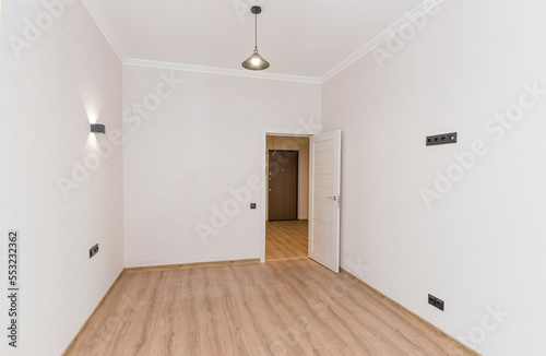 Empty room in light colors after renovation with open door