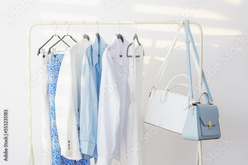 female white and blue capsule summer wardrobe in white room