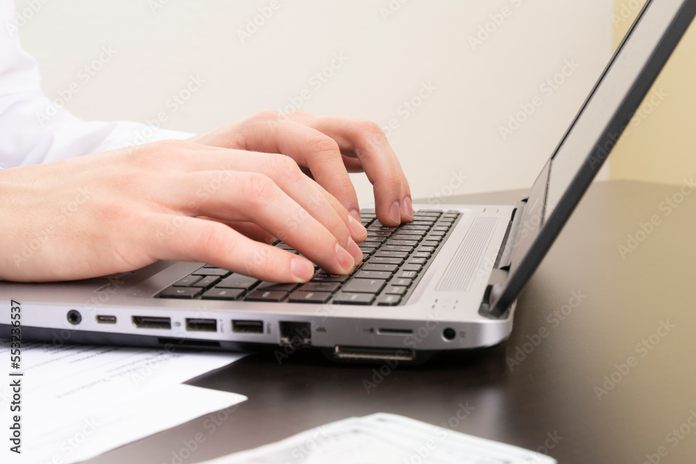 Image of male hands typing on a laptop. close-up. selective focus Image of male hands typing on a laptop. close-up. selective focus