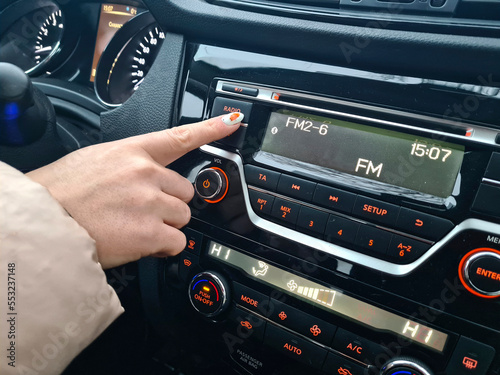 Girl chooses a radio station in the car.