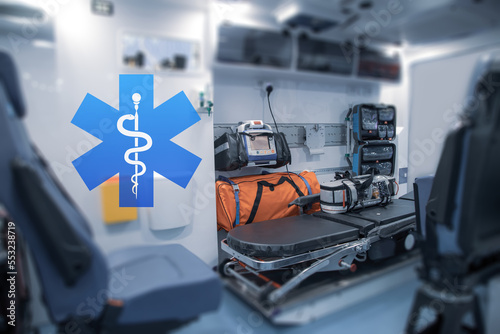 Interior of an ambulance with bed and patient care equipment. Illustration with paramedic logo.