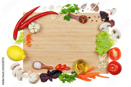 Kitchen cutting board framed with vegetables  herbs and spices. Space for text  top view  mock-up