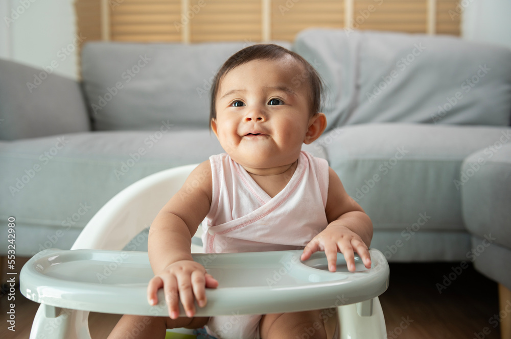 A baby girl ready for eating blend food on baby chair A baby girl ready for eating blend food on baby chair